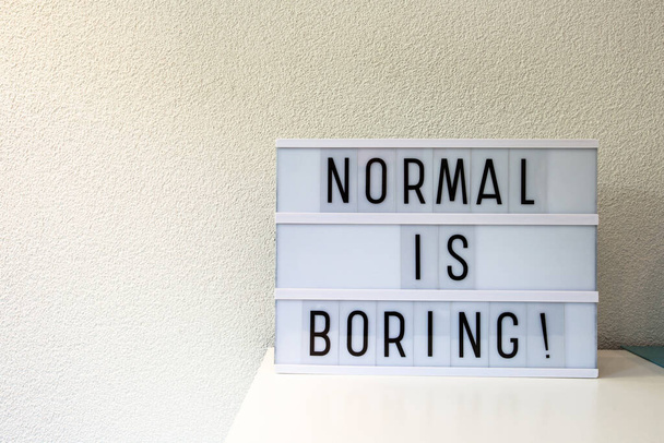 Normal is boring written in Light box home decoration, motivational sign retro home, space for text - Foto, Bild