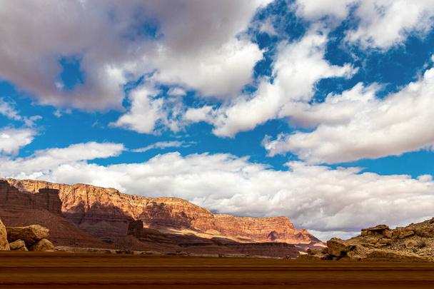 Ευρεία ανοικτούς ουρανούς και κόκκινα βουνά βράχων με λευκά σύννεφα κοντά στη γέφυρα Navajo, AZ, ΗΠΑ - Φωτογραφία, εικόνα