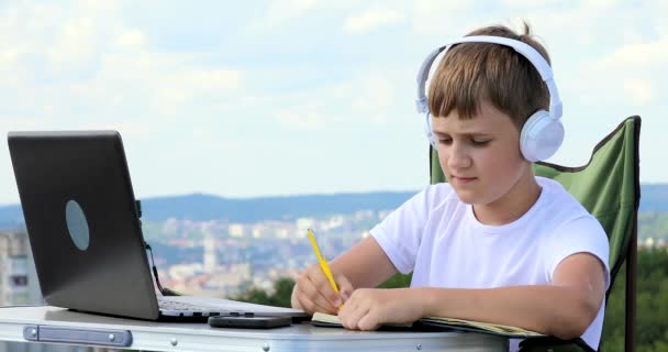 o menino aprende, escreve ideias em um caderno e as transfere para um laptop
 - Filmagem, Vídeo