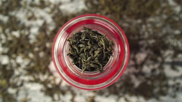 Dry green tea leaves fall into the strainer of the teapot close-up - Video, Çekim