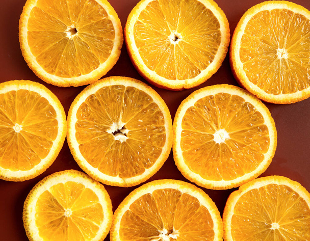 Friss narancsszeletek és rozmaringlevelek színes gyümölcsmintázata termesztett háttéren. - Fotó, kép