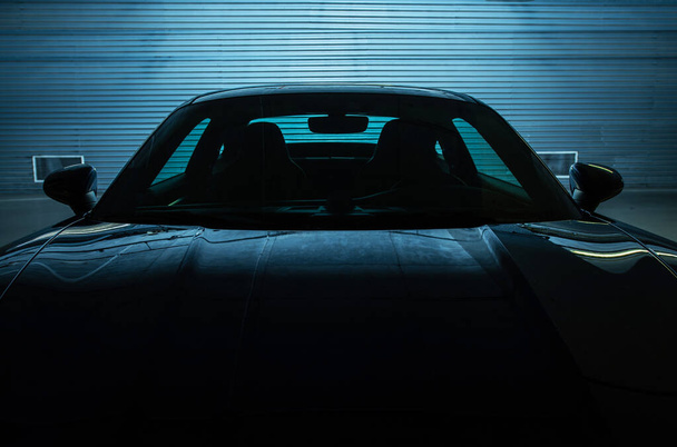 Superdeportivo exótico aparcado en el garaje subterráneo. Color de la iluminación trasera azul oscuro. Concepto de coche deportivo legal de calle de alto rendimiento. Industria automotriz. - Foto, imagen