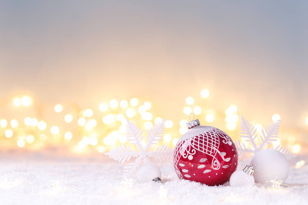 雪の上でお祝いの赤と白の装飾が施されたクリスマスカードテンプレート、ライトボケ、コピースペース  - 写真・画像