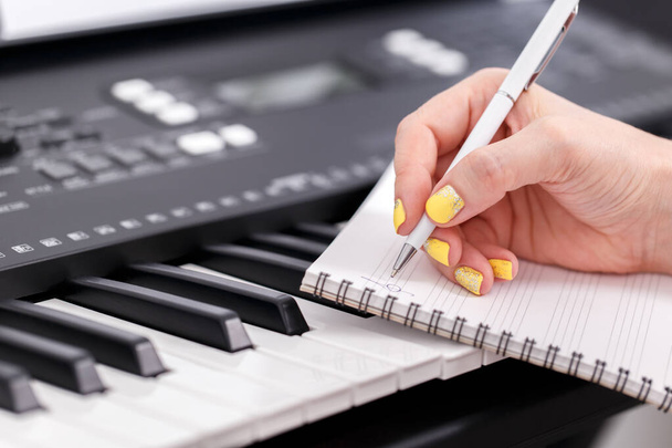 Жінка пише музику, крупним планом доглянуті руки на електронному піаніно
,  - Фото, зображення
