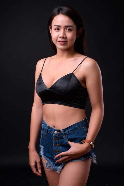 Stúdió lövés fiatal gyönyörű ázsiai transznemű nő fekete háttér - Fotó, kép