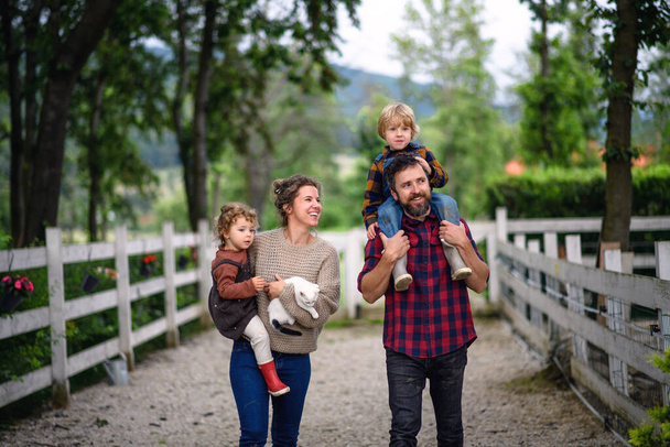 Portrait of family with small children walking on farm. - Фото, зображення
