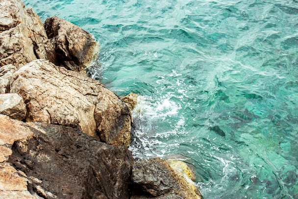 Rocky seashore with turquoise sea water. Background.  - Photo, Image