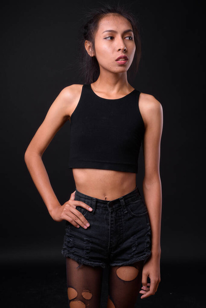 Estudio de tiro de joven hermosa mujer transgénero asiática contra fondo negro - Foto, imagen
