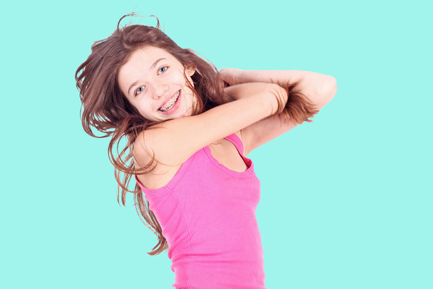mooi jong tiener meisje met beugels op tanden in wit  - Foto, afbeelding
