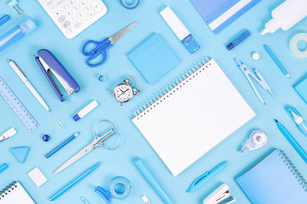 Assorted office and school white and blue stationery and notepad on pastel background. Flat lay knolling with copy space for back to school or education and craft concept. Blue monochrome banner - Photo, image