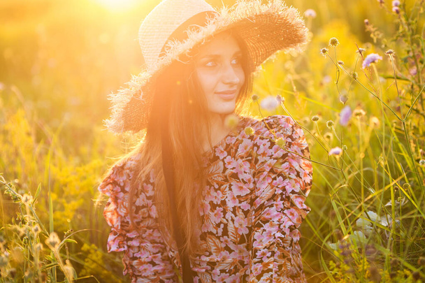 young beautiful european girl in the setting sun, on the field,in hat - Foto, Imagem