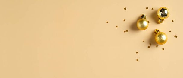 Christmas banner. Background Xmas design of golden balls and glitter confetti stars on yellow background. Christmas header, greeting card mockup. - Photo, image