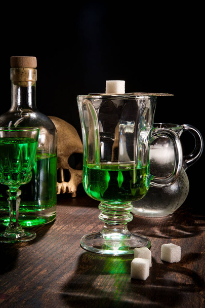 Zöld abszintlikőr üvegben, jeges vízzel, cukorkockára öntve - Fotó, kép