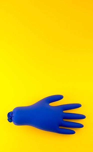 Napompowane niebieskie rękawice medyczne na żółtym tle. Koncepcja ta jest wybuch pandemii 2020 - Zdjęcie, obraz