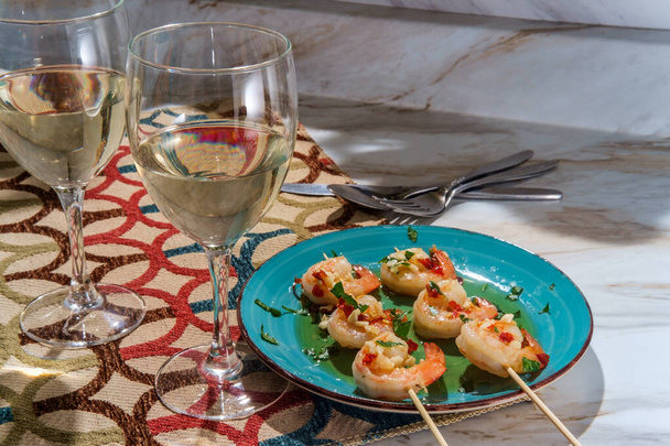 Romantyczny obiad Portugalski gambas al ajillo czosnek krewetki na szaszłyki z dwóch kieliszków pinot grigio białe wino - Zdjęcie, obraz