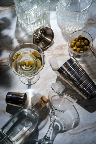 Виготовлення брудного джину мартіні, що готується прямо вгору і прикрашений зеленими оливками
 - Фото, зображення