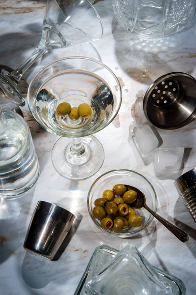 Making likainen gin martini ravisteli tarjoillaan suoraan ylös ja koristeltu vihreitä oliiveja - Valokuva, kuva
