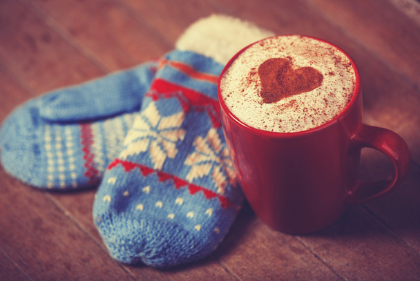 Перчатки и чашки с кофе и форма сердца какао на нем
. - Фото, изображение