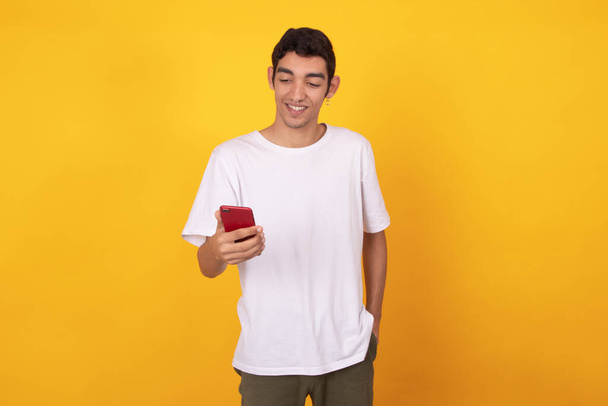 модный молодой человек с мобильным телефоном изолирован на заднем плане - Фото, изображение