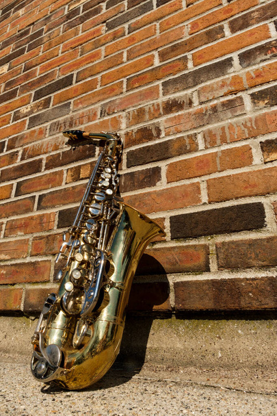 Outdoor Jazz entertainment musical instrument saxophone with grungy street background - Photo, Image