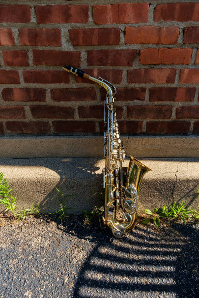 Открытый джазовый саксофон на музыкальных инструментах с грандиозным уличным фоном - Фото, изображение