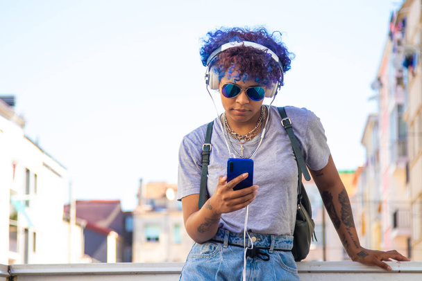 menina urbana com smartphone e fones de ouvido ouvindo música ao ar livre na cidade - Foto, Imagem