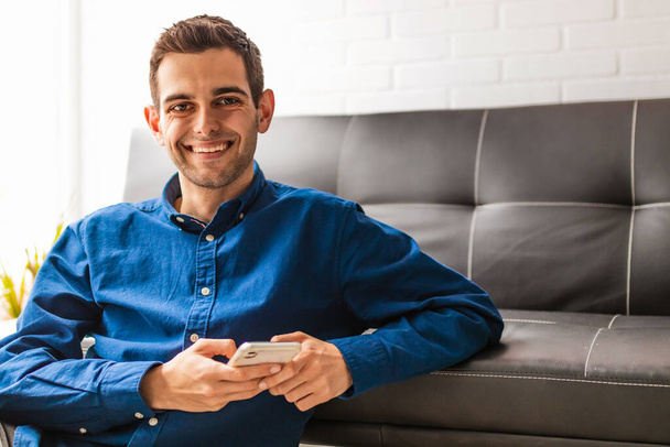 portrait of young man with mobile phone at home - Photo, Image