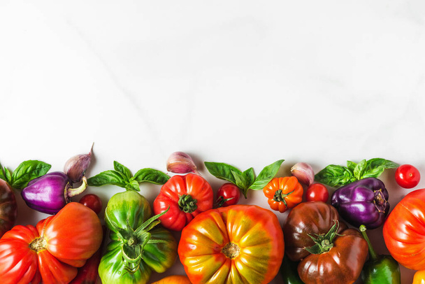 Fond de légumes biologiques colorés frais. Tomates crues, poivre et herbes sur fond blanc. alimentation saine nourriture. vue supérieure avec espace de copie - Photo, image