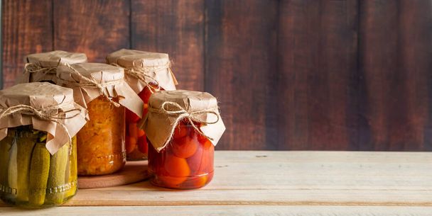Vasi di verdure fermentate su fondo ligneo. Cetrioli in scatola fatti in casa, pomodori e crauti. - Foto, immagini
