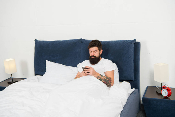 Check email. First of all. Bearded man texting sms in bed. Hipster send message using smartphone. Mobile message. Short message service. Mobile lifestyle. Social networks. Download application - Foto, Imagem