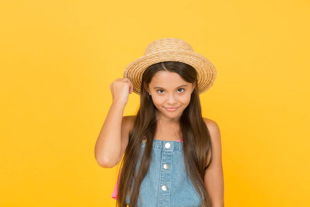 Effortless beauty. beach fashion for kids. small child on yellow background. holiday joy and activity. beauty. long-awaited summer vacation. happy childhood. cheerful little girl wear straw hat - Foto, imagen