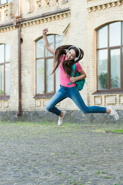 Energetic child girl jumping dancing listening music headphones, real happiness concept - 写真・画像