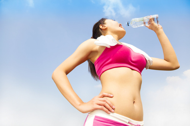 junge Frau trinkt Wasser nach Laufeinheit - Foto, Bild