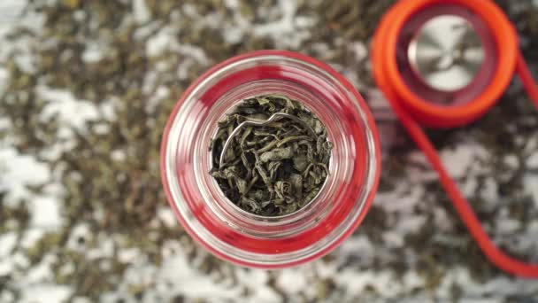 teaspoon adds dried green tea leaves to the teapot - Materiaali, video