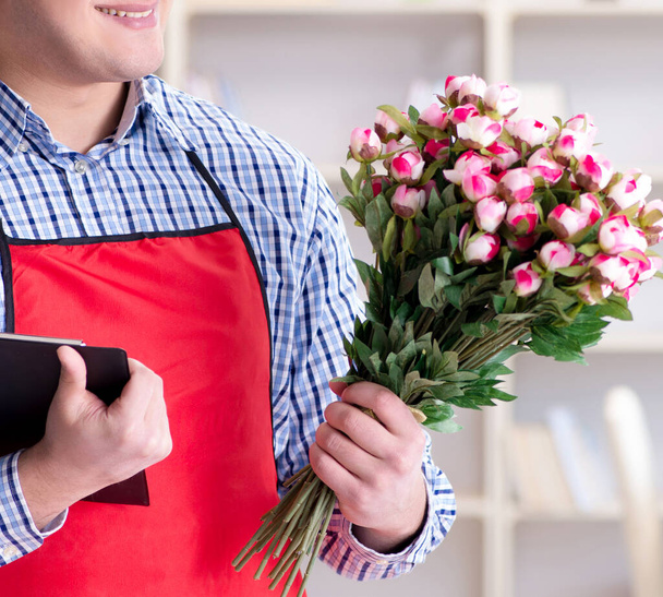 Секретарь цветочного магазина предлагает букет цветов - Фото, изображение
