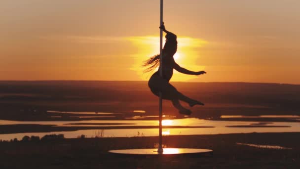 Pole Dance bei Sonnenuntergang - junge Frau dreht sich auf der Tanzstange - Filmmaterial, Video