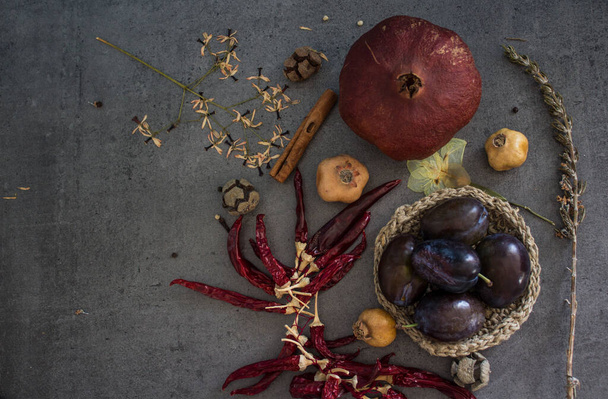 Stilleven met gedroogde vruchten, kruiden en groenten op grijze textuur achtergrond met kopieerruimte. Herfst stemming plat lay.  - Foto, afbeelding
