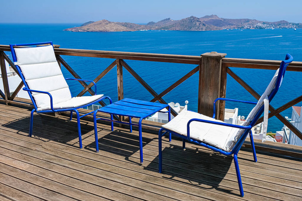 terrasse en bois de villa de vacances ou hôtel avec deux chaises blanches et table et vue sur la mer - Photo, image