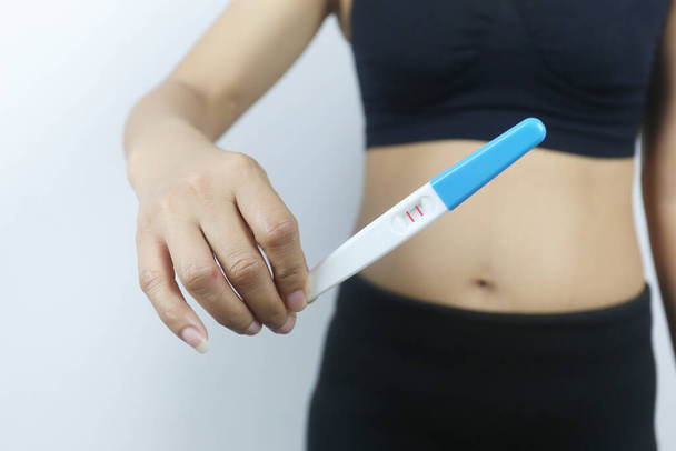 Ferramenta de teste de gravidez na mão da mulher, Resultados dos testes Demonstrando gravidez, Uma mulher de vestido preto. - Foto, Imagem