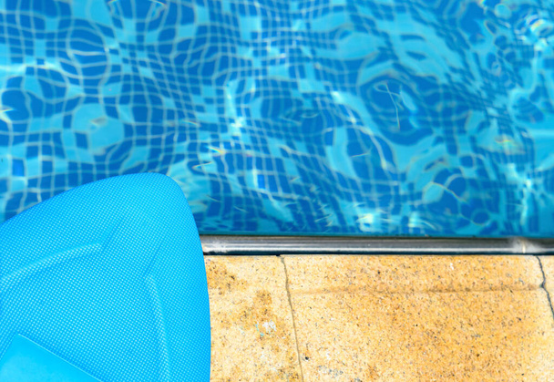 blauwe drijvende pad aan de rand van een zwembad - Foto, afbeelding