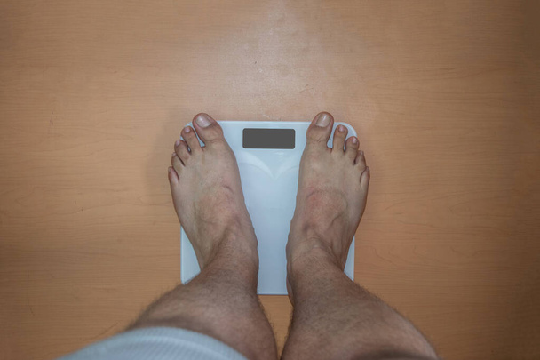 толстяк взвешивает себя в цифровом масштабе - Фото, изображение