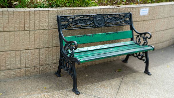 There is a park green and black bench at the sideway  - Photo, Image