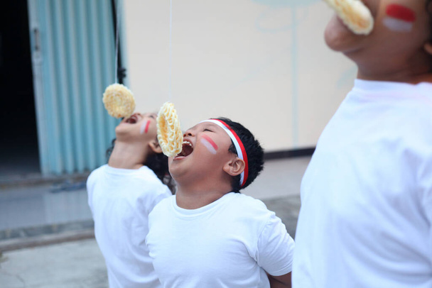 Индонезийские дети едят крекеры в честь Дня независимости Индонезии - Фото, изображение