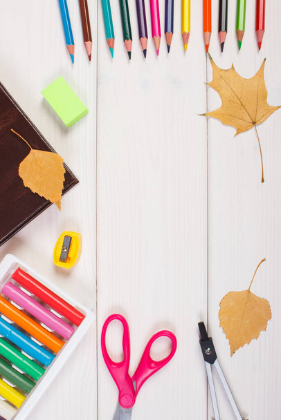 Frame of office accessories, book and orange leaves on boards, copy space for text or inscription, back to school and autumn concept - Foto, immagini