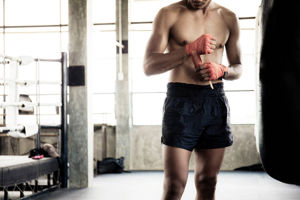 Boxer está intercambiando manos y saco de boxeo en el ring de boxeo. - Foto, Imagen