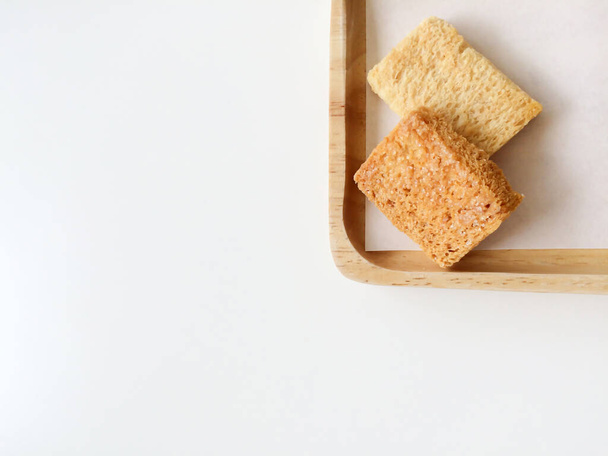 Rapeaa leipää voita sokeri puinen tarjotin valkoisella pohjalla. Keksejä kotitekoisia. Jälkiruoka, Snack. Huippunäkymä. Lähemmäs. Litteä. - Valokuva, kuva