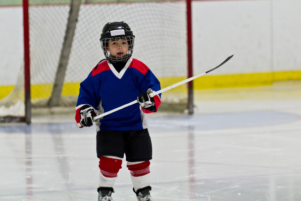 Petit garçon jouant au hockey sur glace dans une arène
 - Photo, image