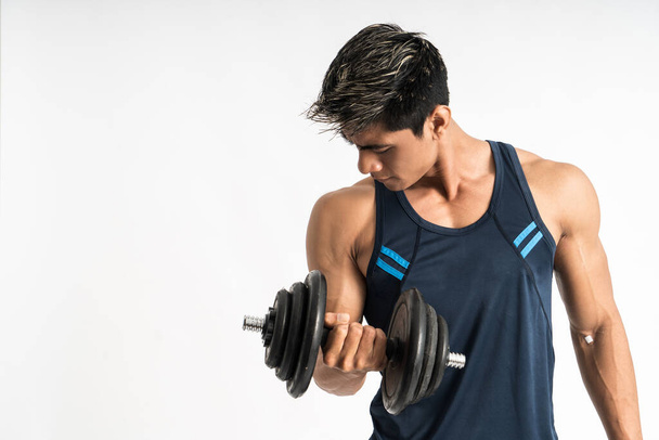 Asian man muscles lift dumbbell weights with energy in the biceps - Φωτογραφία, εικόνα