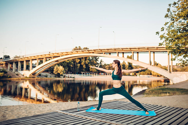 Sportlerin macht Yoga auf Holzplattform - Foto, Bild