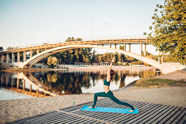 Desportista fazer ioga na plataforma de madeira
 - Foto, Imagem